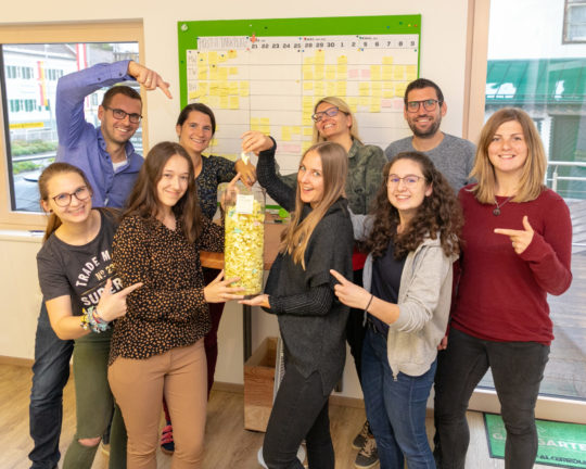 Das FALKEmedia-Team mit der gläsernen Vase voller Postits